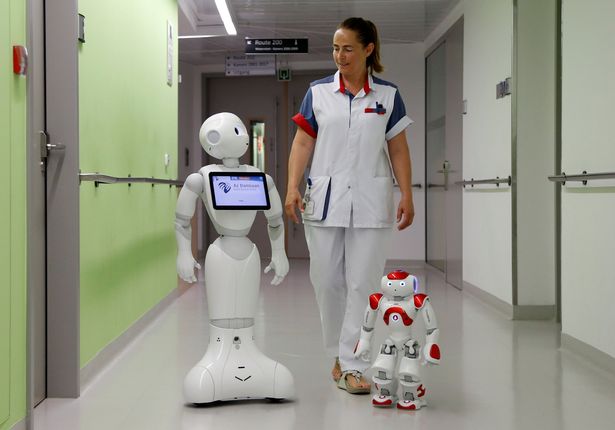 A-nurse-walks-with-Pepper-L-and-Zora-the-robots