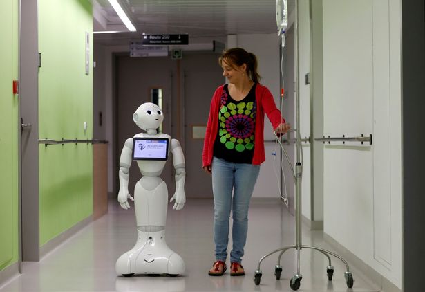A-woman-walks-with-new-recruit-Pepper-the-robot
