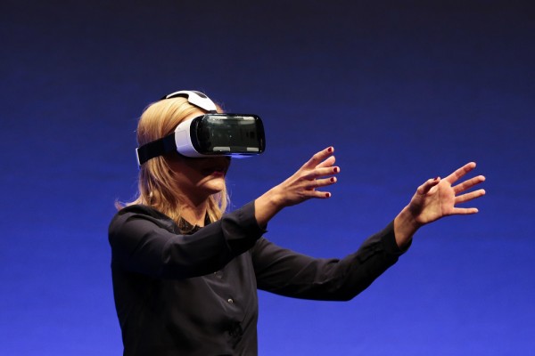 FILE - In this Wed., Sept. 3, 2014 file photo, British television presenter Rachel Riley shows a virtual-reality headset called Gear VR during an unpacked event of Samsung ahead of the consumer electronic fair IFA in Berlin. Oculus, the virtual reality company acquired by Facebook earlier this year for $2 billion, is holding its first-ever developers conference and is expected to discuss the much-anticipated release of its VR headset for consumers. The two-day Oculus Connect conference begins Friday, Sept. 19, 2014. (AP Photo/Markus Schreiber, file)